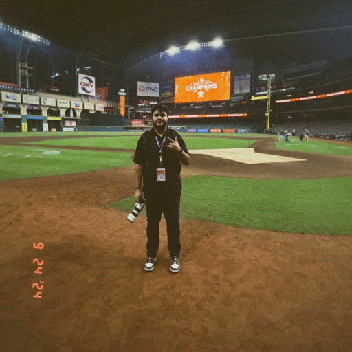 José D. Porteles on the field with his camera during a baseball assignment